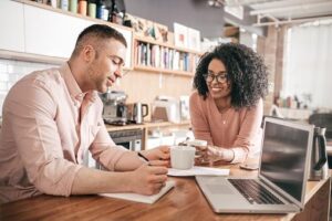man and woman leaning on a counter discussing a budget