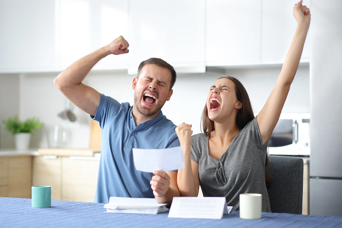 excited couple celebrating lowering their payments