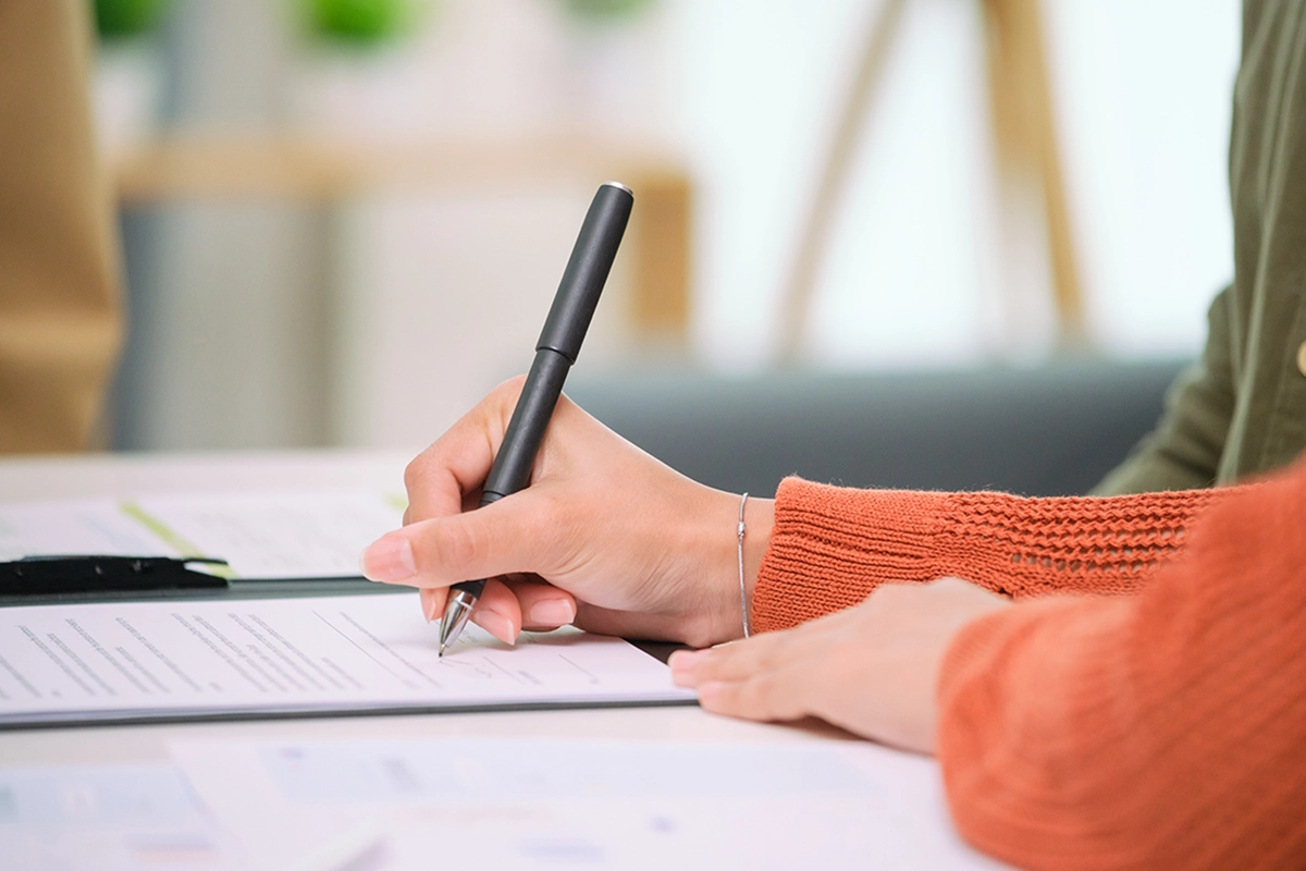 woman signing paperwork