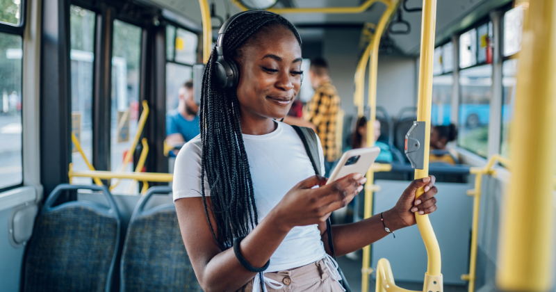 African american woman using smartphone while riding a bus