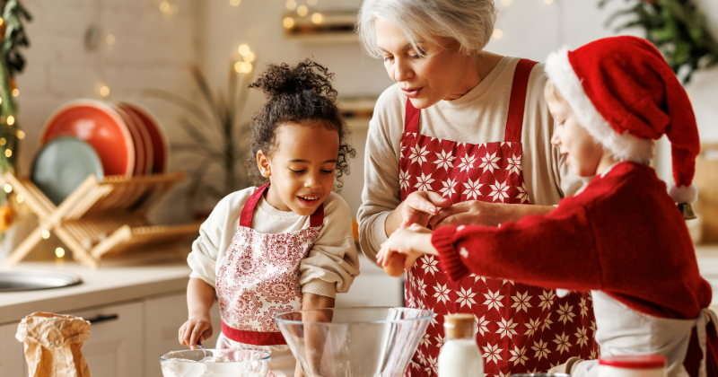 visa for holidays_2025-2-stock (1) Happy multiracial kids help grandmother to cook Christmas cookies in kitchen during winter holidays