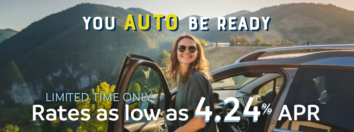 young girl getting out of her car in front of an overlook with mountains in the background